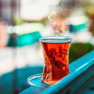 A steaming cup of Turkish tea on a windowsill with blurred background in Gaziantep.